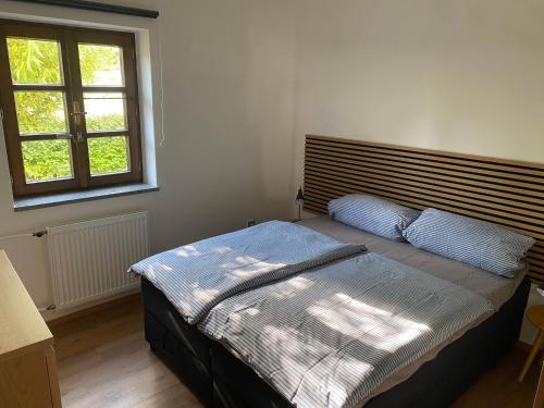 a bedroom with a bed with a wooden headboard and a window at Apartmán Maya in Horní Planá
