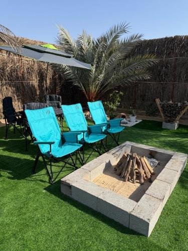 a group of chairs and a fire pit in a yard at the farm break in Madīnat Zāyid