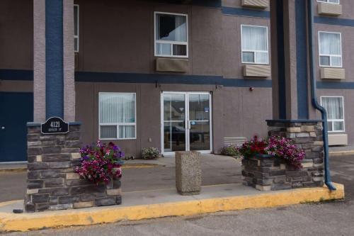 a building with two flowers in front of it at Super 8 by Wyndham Whitecourt in Whitecourt
