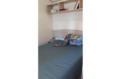 une chambre avec un lit recouvert d'une couverture bleue dans l'établissement Feriendorf Le Tamerici Mobilehome Gorgona für 5 Personen, à Marina di Cecina