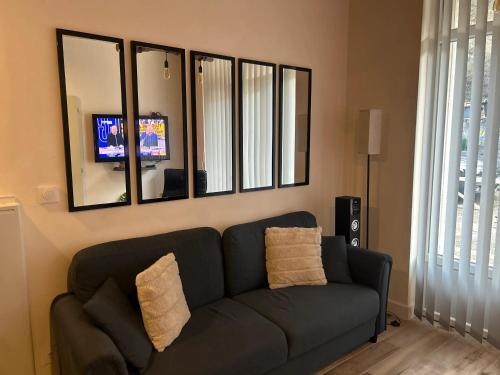 a living room with a couch and a mirror at Appartement charmant à Savignac-les-Ormeaux, 56 m², balcon in Savignac-les-Ormeaux