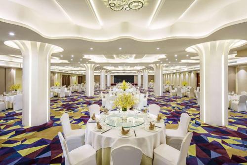 a banquet hall with white tables and white chairs at Wyndham Garden Suzhou in Suzhou