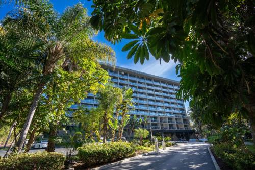 a building with palm trees in front of a street at Hotel La Jolla, Curio Collection by Hilton in San Diego