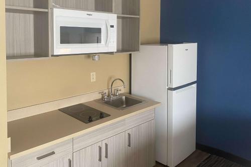 a small kitchen with a sink and a microwave at Suburban Studios Arlington Heights Elk Grove in Arlington Heights