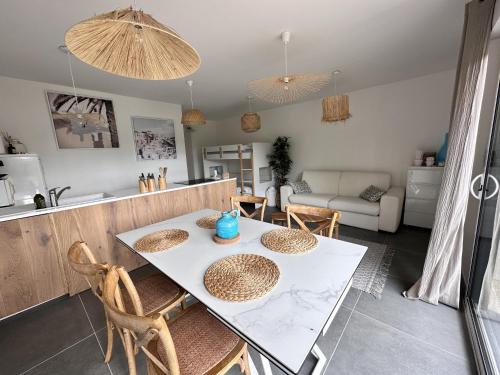 a kitchen and living room with a table and chairs at L'Opale - Le White in Les Attaques