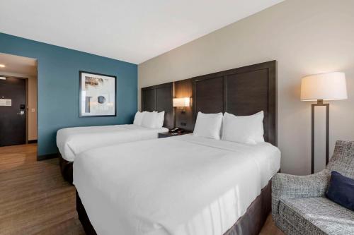 a hotel room with two beds and a couch at Comfort Inn & Suites Miami International Airport in Miami