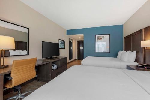 a hotel room with a bed and a desk and a tv at Comfort Inn & Suites Miami International Airport in Miami