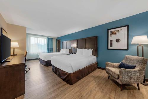 a hotel room with two beds and a flat screen tv at Comfort Inn & Suites Miami International Airport in Miami