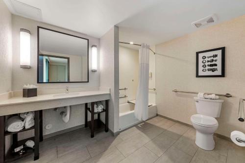 a bathroom with a toilet and a sink and a mirror at Comfort Inn & Suites Miami International Airport in Miami
