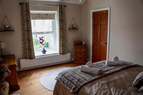 una camera da letto con un letto grande e una finestra di Mill Cottage a Clitheroe