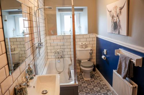 un bagno con vasca, WC e lavandino di Mill Cottage a Clitheroe