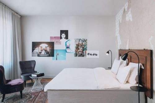 una camera da letto con un letto bianco e una sedia di Story Hotel Riddargatan, part of JdV by Hyatt a Stoccolma