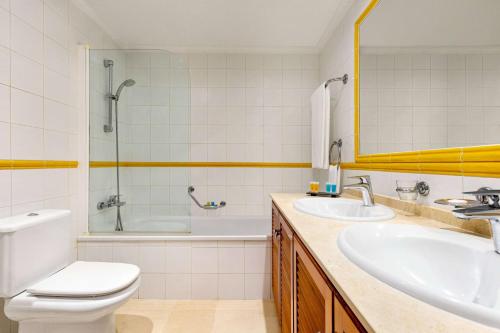 a bathroom with a sink and a toilet and a tub at Wyndham Grand Costa del Sol in Mijas Costa