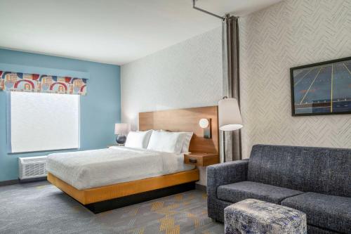 琼斯伯勒Home2 Suites By Hilton Jonesboro的配有床和沙发的酒店房间