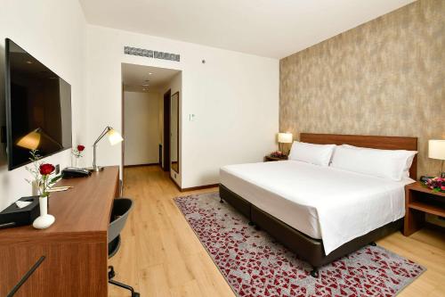a bedroom with a bed and a desk and a television at Comfort Hotel Riyadh Olaya in Riyadh