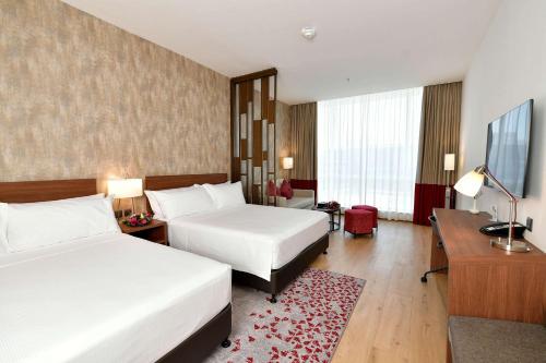 a hotel room with two beds and a television at Comfort Hotel Riyadh Olaya in Riyadh
