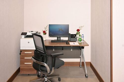 an office with a desk with a computer and a chair at Comfort Hotel Riyadh Olaya in Riyadh