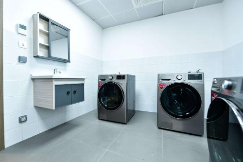a laundry room with two washing machines and a sink at Comfort Hotel Riyadh Olaya in Riyadh