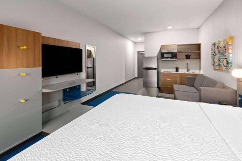 a large room with a bed and a living room at Microtel Inn & Suites by Wyndham Olive Branch in Olive Branch