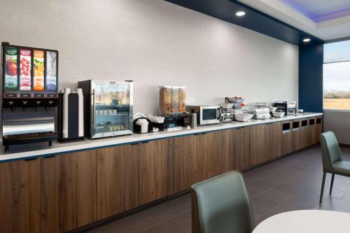 a restaurant with a counter with a food counter at Microtel Inn & Suites by Wyndham Olive Branch in Olive Branch