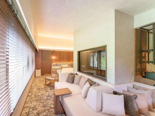 a living room with a large white couch at Kamikochi Lemeiesta Hotel in Matsumoto