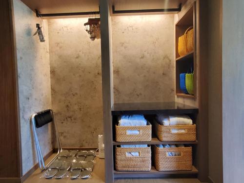 a walk in shower with baskets in a bathroom at Kamikochi Lemeiesta Hotel in Matsumoto