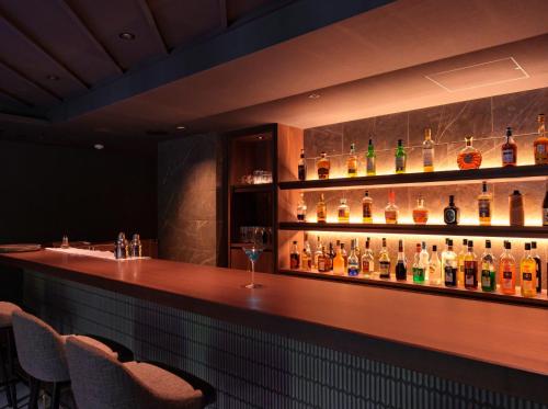 a bar with a bunch of bottles of alcohol at Kamikochi Lemeiesta Hotel in Matsumoto