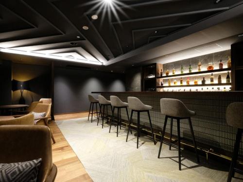 a bar with a row of stools in a room at Kamikochi Lemeiesta Hotel in Matsumoto