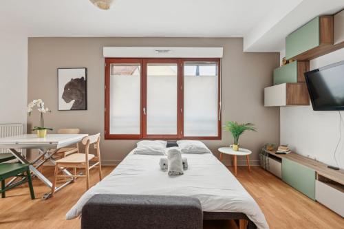 a living room with a bed and a dining room table at Grand Appart Rénové Paris et Disneyland 4pers in Neuilly-sur-Marne