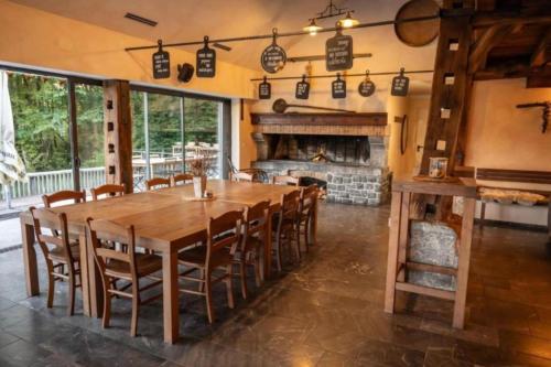a dining room with a table and chairs and a fireplace at Luxury Chalet Martin in Grosuplje