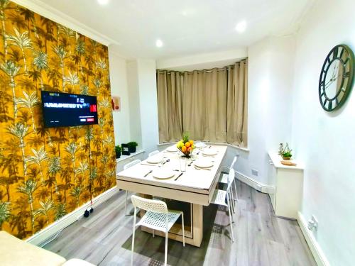 a dining room with a table and a tv on a wall at Liverpool 4 Bed Home Sleeps 18 Free Parking in Liverpool