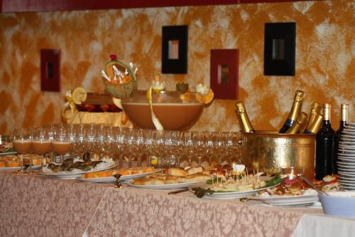 a buffet with plates of food and bottles of wine at Park Hotel in Chieri
