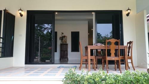 Una mesa y sillas de madera en un patio. en Baan Peaceful Villa 2, Ao Nang, en Krabi