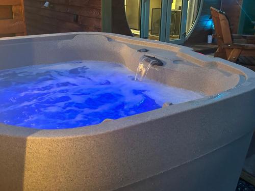 a hot tub with blue water in it at Barnharrow Holiday Pods in Newton Stewart