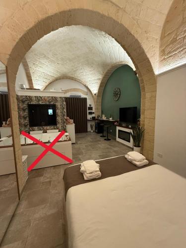 a room with two beds in a room with an arch at Nicole Suite in San Ferdinando di Puglia