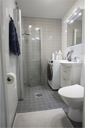 a bathroom with a shower and a toilet and a sink at A two-bedroom with river view in Kajaani