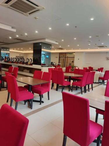 a dining room with red chairs and tables at Puteri Bay Hotel in Melaka