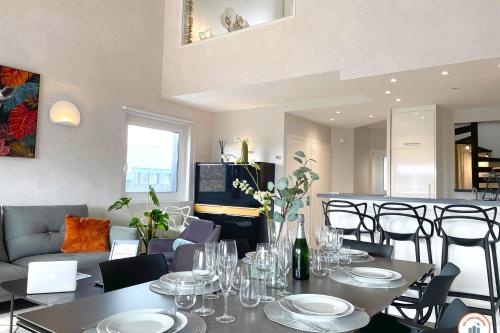 une salle à manger avec une table, des verres et des chaises dans l'établissement Le Majestic - Vue Mer - Plage - Casino, à Deauville