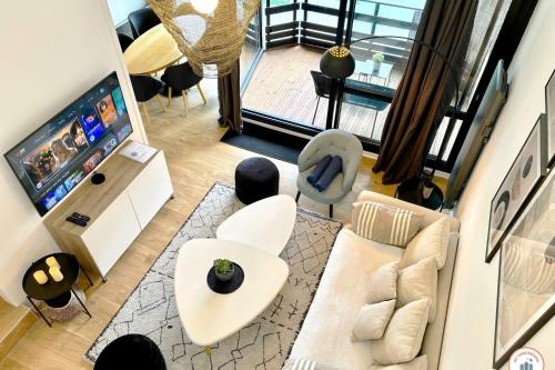 - une vue de tête sur un salon avec une télévision dans l'établissement Le White Pearl - Marina - Terrasse, à Deauville