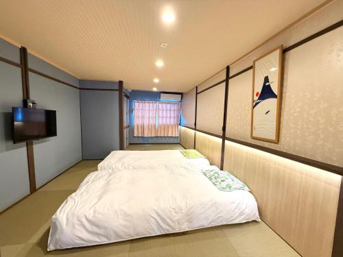 a bedroom with two beds and a tv in it at ゆいの宿大阪城east1号室 in Osaka