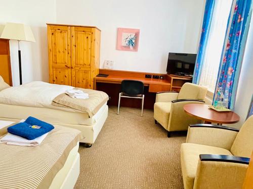 a hotel room with two beds and a desk and chairs at Boizenburg Bliss in Boizenburg