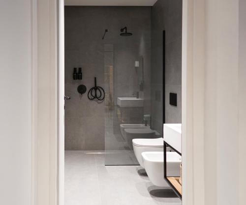 a bathroom with two toilets and a shower at SANBE 17 Loft House in Bergamo