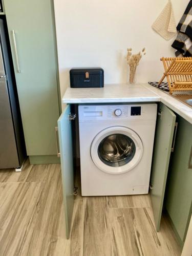 a washing machine in a kitchen with a counter at Anura - Luxurious Stay, 100m leap to the Beach! in Jeffreys Bay