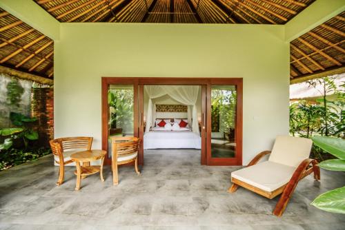 a bedroom in a villa with a bed and chairs at The Hidden Paradise Ubud - CHSE Certified in Ubud
