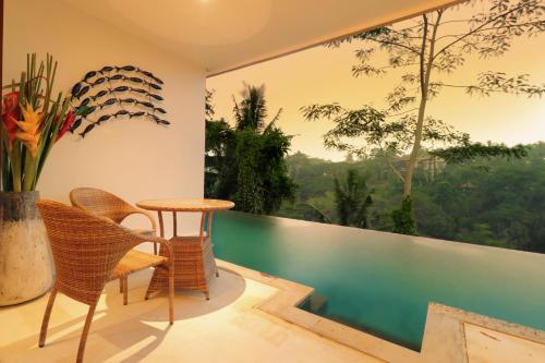 a room with a balcony with a table and chairs at The Hidden Paradise Ubud - CHSE Certified in Ubud
