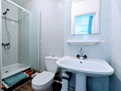 une salle de bain blanche avec des toilettes et un lavabo dans l'établissement La Villa Oscar en plein cœur de ville, à Dax