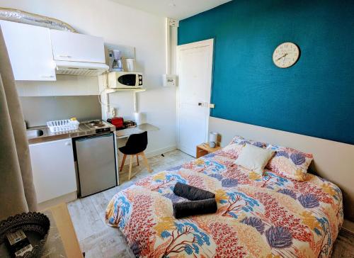 - une chambre dotée d'un lit avec une horloge murale dans l'établissement La Villa Oscar en plein cœur de ville, à Dax