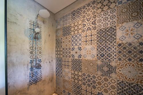 a bathroom with tiled walls and a shower at The Hidden Paradise Ubud - CHSE Certified in Ubud
