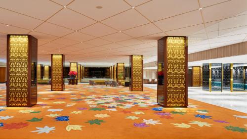 a large lobby with a carpet of leaves on the floor at RIHGA Royal Hotel Osaka, Vignette Collection by IHG in Osaka