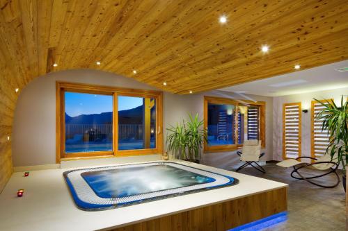 - un bain à remous dans une chambre dotée d'un plafond en bois dans l'établissement Chalet ARAVIS COSY - Spa & piscine, à Saint-Jean-de-Sixt